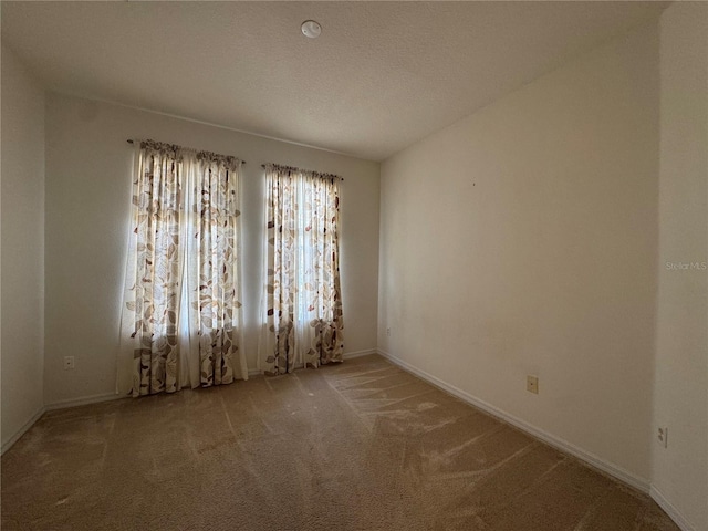 carpeted spare room featuring a textured ceiling