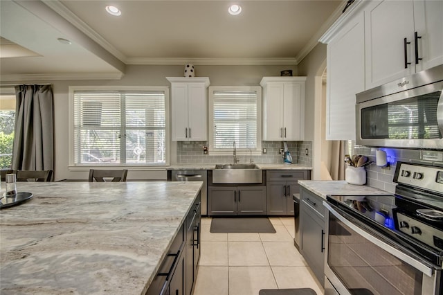 kitchen with white cabinets, sink, stainless steel appliances, and plenty of natural light