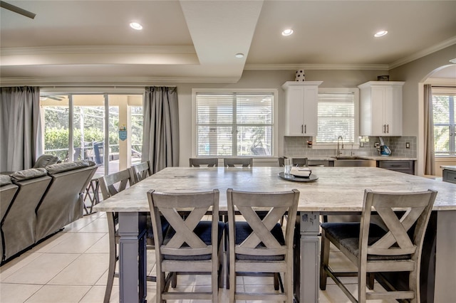 kitchen featuring sink, a kitchen bar, white cabinetry, and a kitchen island