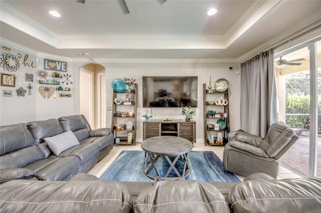 living room with ornamental molding, a tray ceiling, and ceiling fan