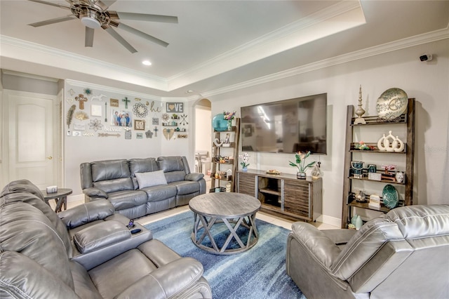 living room with ornamental molding, a tray ceiling, and ceiling fan