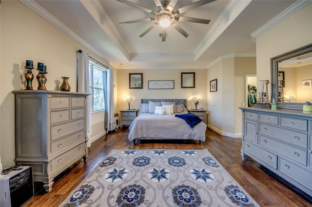 bedroom with a tray ceiling, ceiling fan, crown molding, and dark hardwood / wood-style flooring