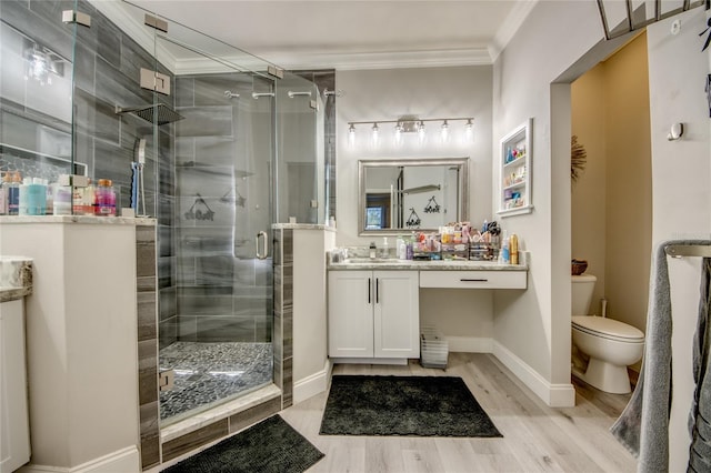 bathroom featuring a shower with shower door, vanity, crown molding, toilet, and hardwood / wood-style floors