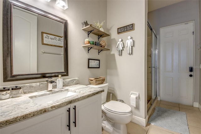 bathroom with tile patterned flooring, a shower with door, vanity, and toilet