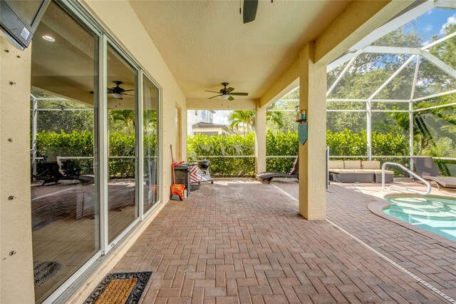 view of patio / terrace featuring ceiling fan and glass enclosure