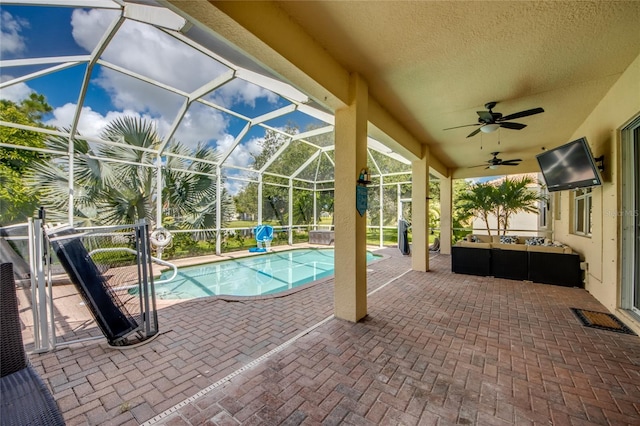 view of pool featuring an outdoor living space, a lanai, ceiling fan, and a patio area