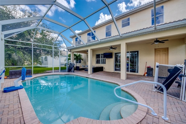 view of pool featuring glass enclosure, ceiling fan, and a patio