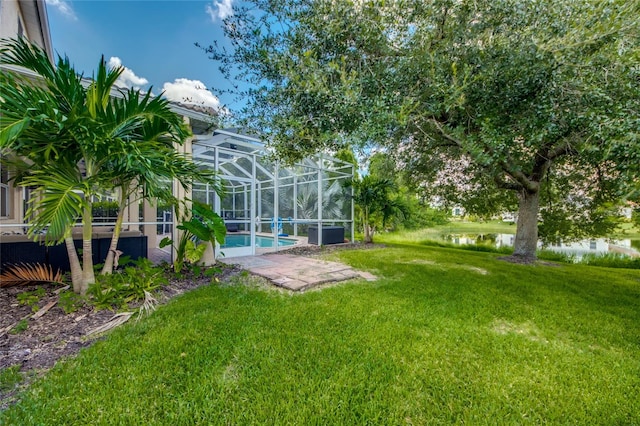 view of yard with glass enclosure and a water view