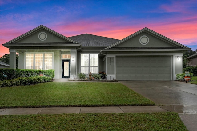 view of front of property with a garage and a yard