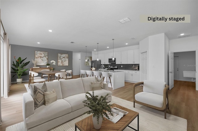 living room with sink and light hardwood / wood-style flooring