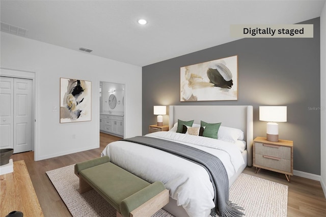 bedroom with a closet, ensuite bathroom, and hardwood / wood-style floors