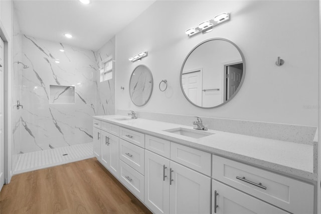 bathroom with vanity, tiled shower, and hardwood / wood-style floors