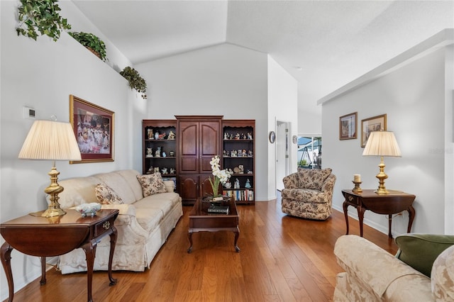 living room with light hardwood / wood-style floors and vaulted ceiling