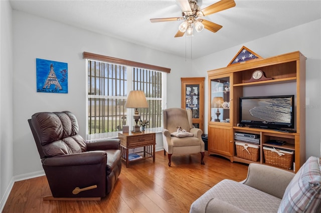 living room featuring wood-type flooring and ceiling fan