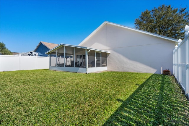 rear view of property with a lawn and a sunroom