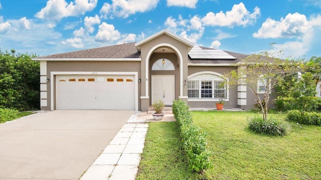 ranch-style home featuring a garage, solar panels, and a front lawn