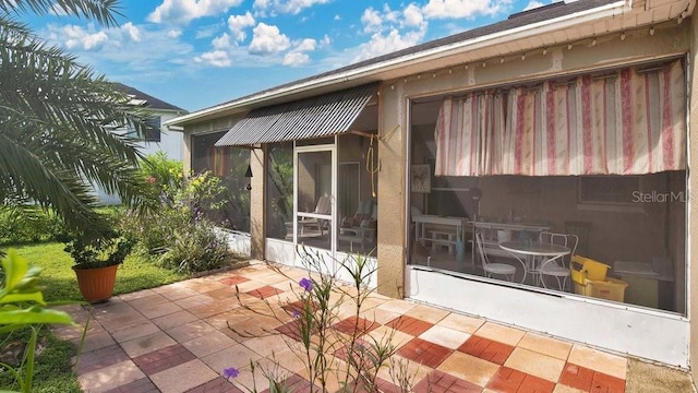 rear view of property featuring a sunroom and a patio area