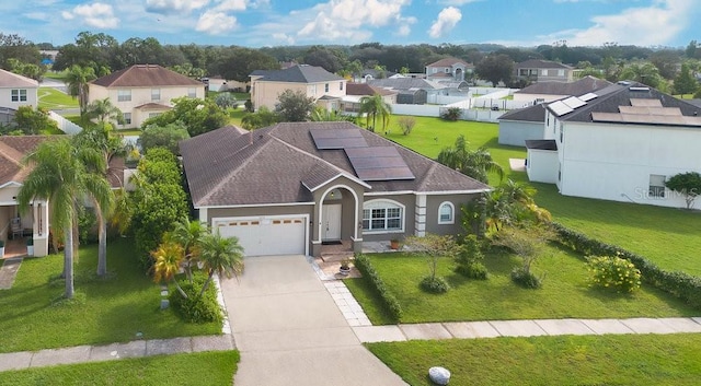 exterior space featuring a front yard, a garage, and solar panels