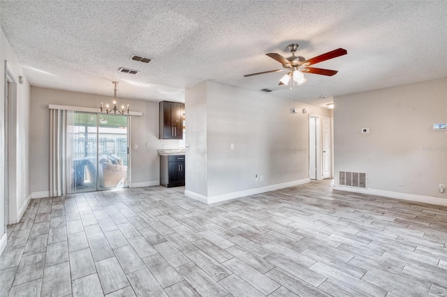 unfurnished living room with light hardwood / wood-style flooring, a textured ceiling, and ceiling fan with notable chandelier