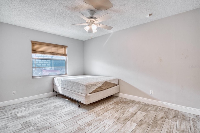 unfurnished bedroom featuring a textured ceiling, light wood-type flooring, and ceiling fan