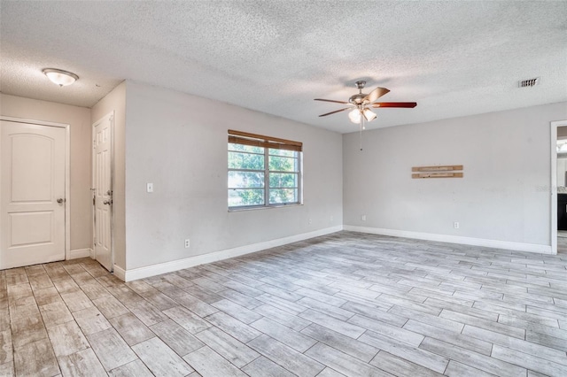 spare room with a textured ceiling, light wood-type flooring, and ceiling fan