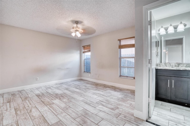 spare room with light hardwood / wood-style floors, a textured ceiling, and ceiling fan