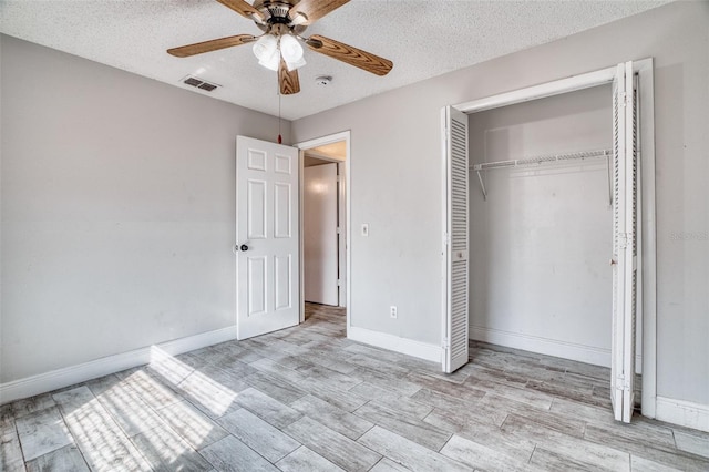 unfurnished bedroom with ceiling fan, a textured ceiling, and light hardwood / wood-style floors