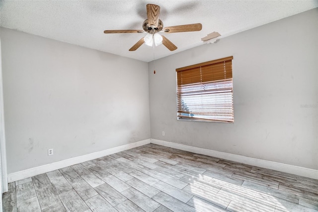 empty room with a textured ceiling, light hardwood / wood-style floors, and ceiling fan