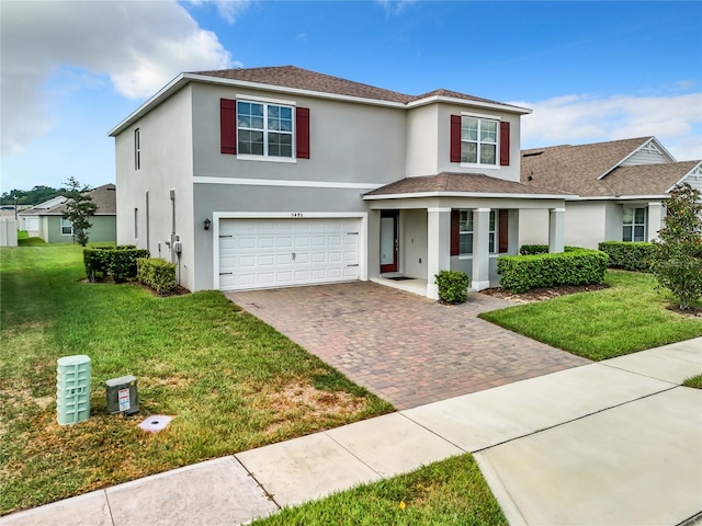 view of property with a garage and a front lawn