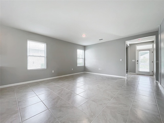 tiled spare room featuring plenty of natural light