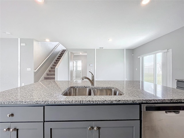 kitchen featuring a kitchen island with sink, sink, a healthy amount of sunlight, and stainless steel dishwasher