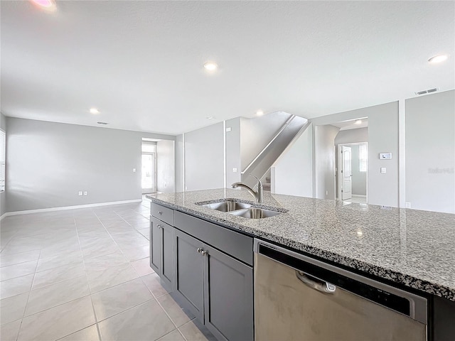 kitchen featuring light stone counters, light tile patterned floors, sink, gray cabinetry, and dishwasher