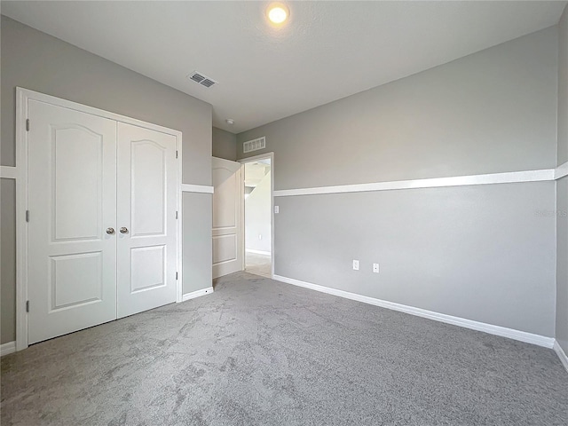 unfurnished bedroom with a closet and carpet flooring