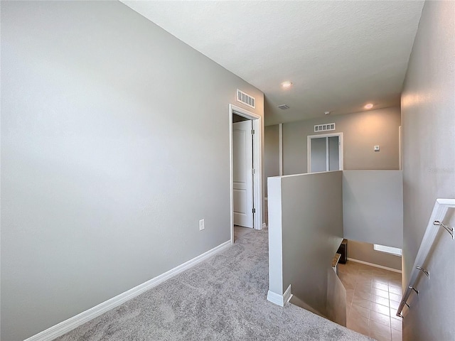 hall with light colored carpet