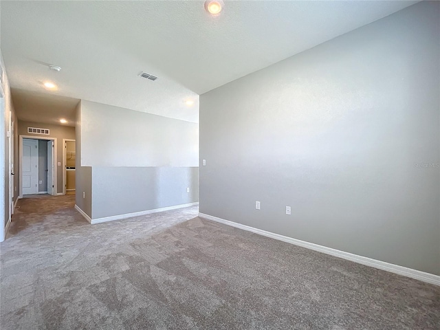 carpeted empty room with vaulted ceiling