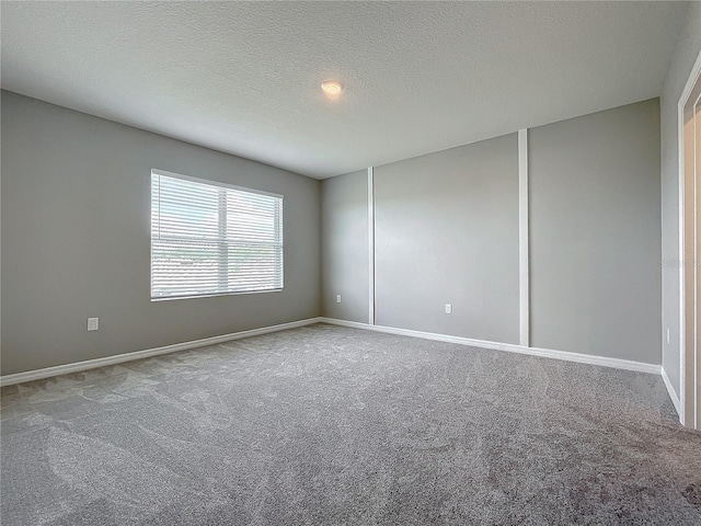 empty room with a textured ceiling and carpet