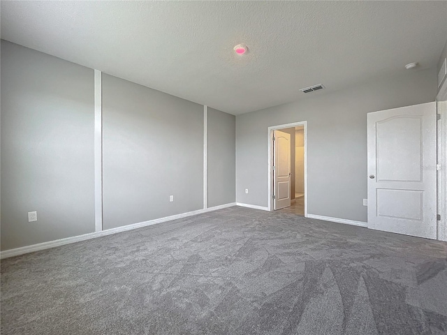 carpeted empty room featuring a textured ceiling