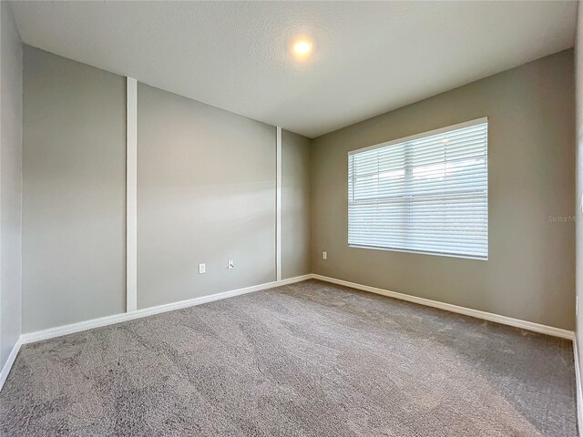 carpeted spare room with a textured ceiling