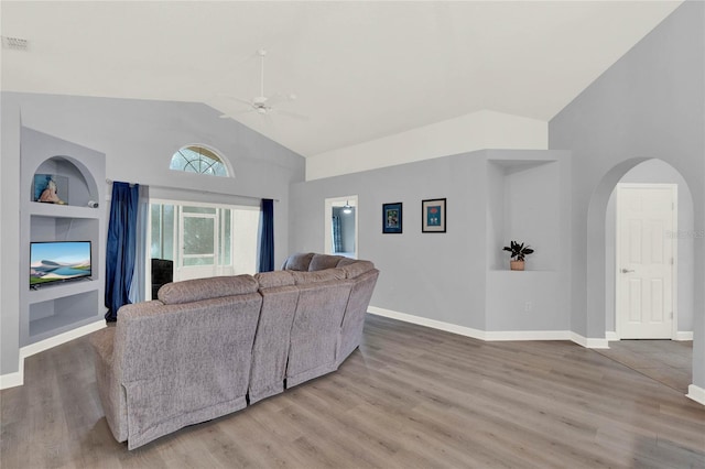 living room with hardwood / wood-style flooring, lofted ceiling, and built in shelves