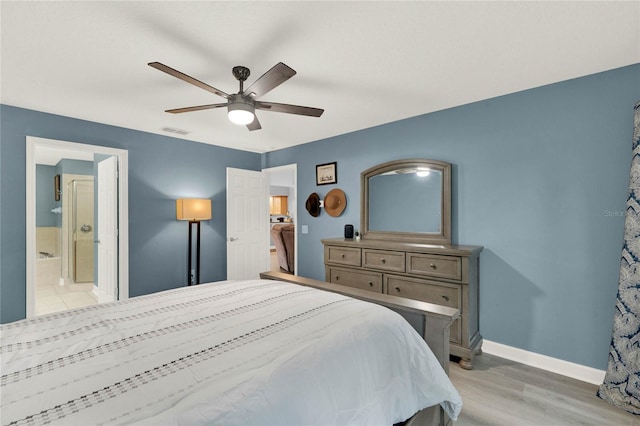 bedroom featuring connected bathroom, ceiling fan, and light wood-type flooring