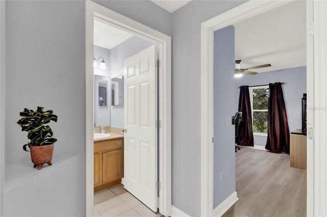 hallway with sink and light wood-type flooring