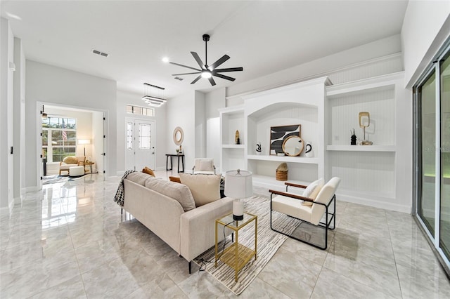 living room with ceiling fan and built in features