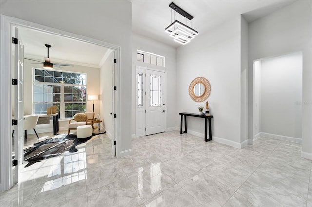 entrance foyer featuring crown molding and ceiling fan