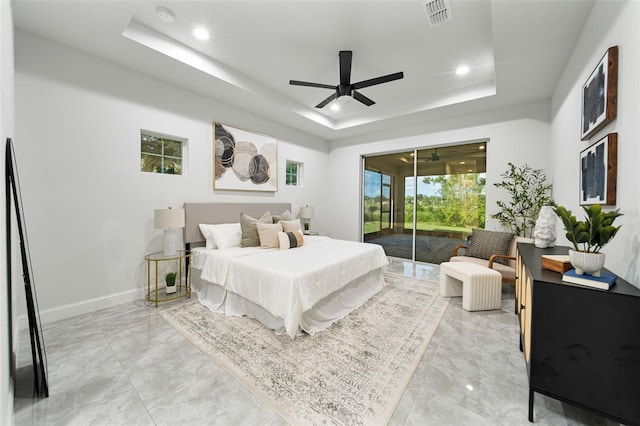 bedroom featuring ceiling fan, a tray ceiling, and access to outside