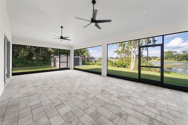 unfurnished sunroom with a water view and ceiling fan