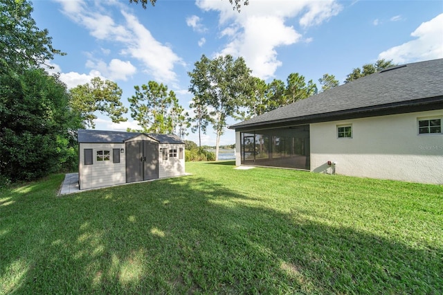 view of yard with a sunroom and a storage unit