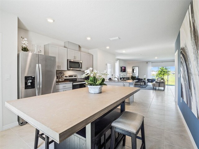 kitchen with light tile patterned flooring, appliances with stainless steel finishes, and gray cabinets