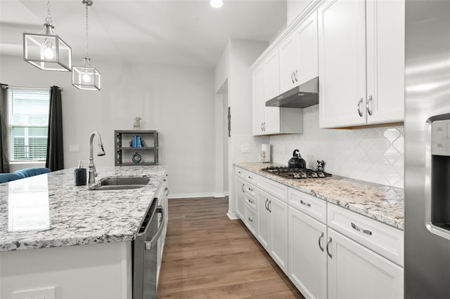 kitchen with appliances with stainless steel finishes, sink, light wood-type flooring, an island with sink, and white cabinets