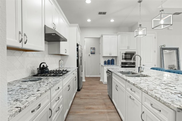 kitchen with light hardwood / wood-style flooring, range hood, sink, white cabinets, and appliances with stainless steel finishes