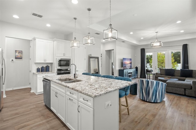 kitchen with sink, white cabinetry, a kitchen island with sink, and stainless steel appliances